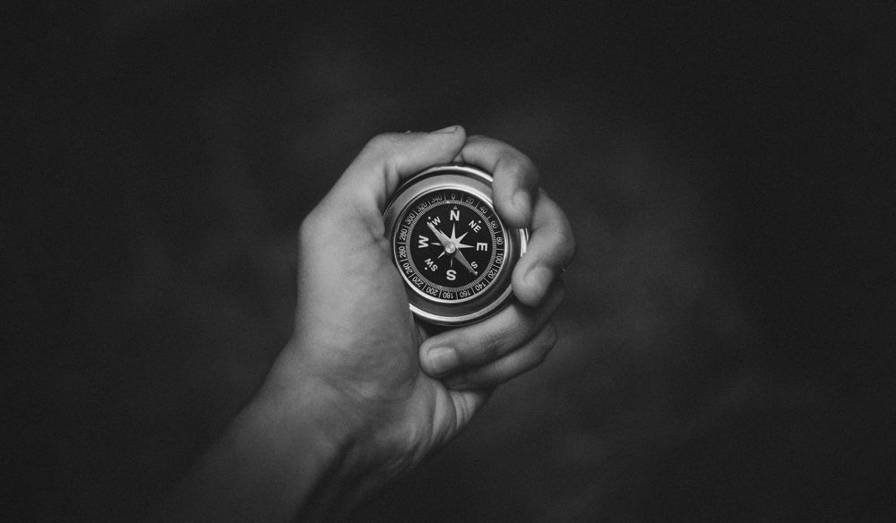 Hand holding a compass